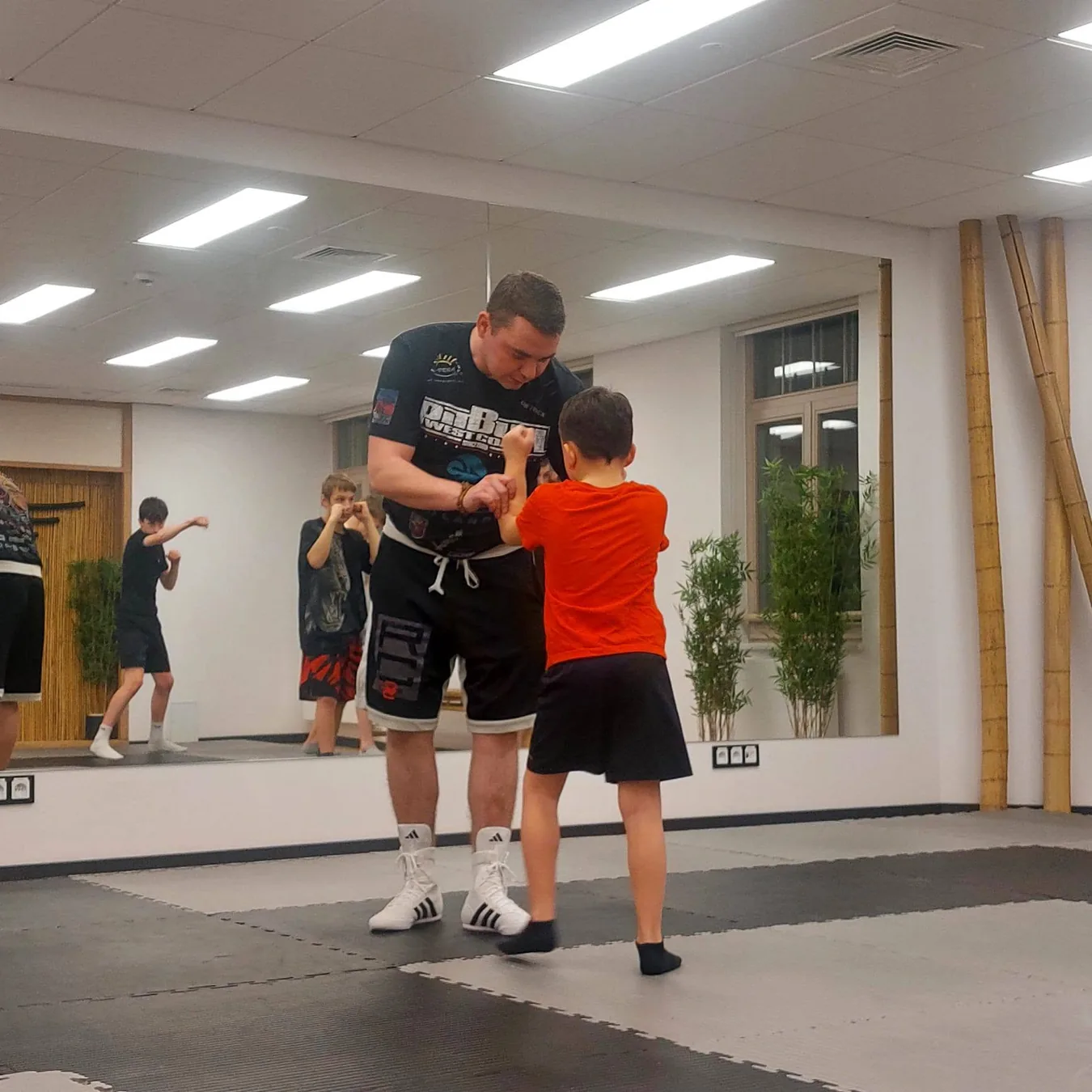 Trener prowadzący trening bokserski z młodym zawodnikiem